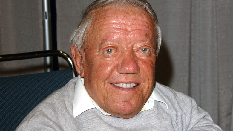 kenny baker grey sweater sat smiling 