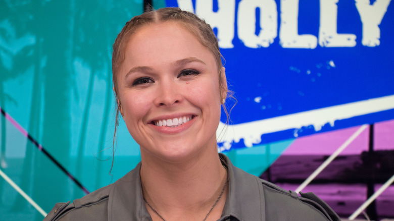 Ronda Rousey smiling grey jacket at event