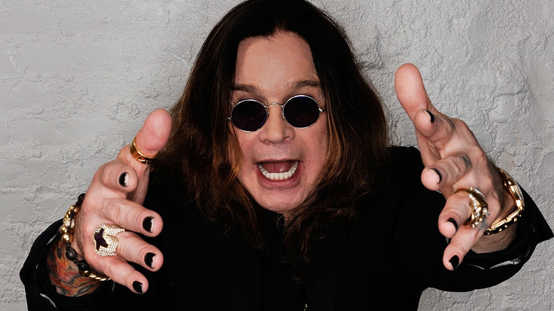 ozzy osbourne sunglasses arms raised yelling