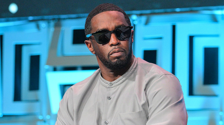 Sean Combs wearing sunglasses against a blue background