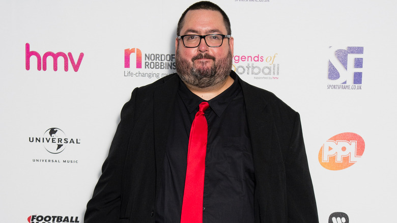 Ewen MacIntosh black suit red tie at event
