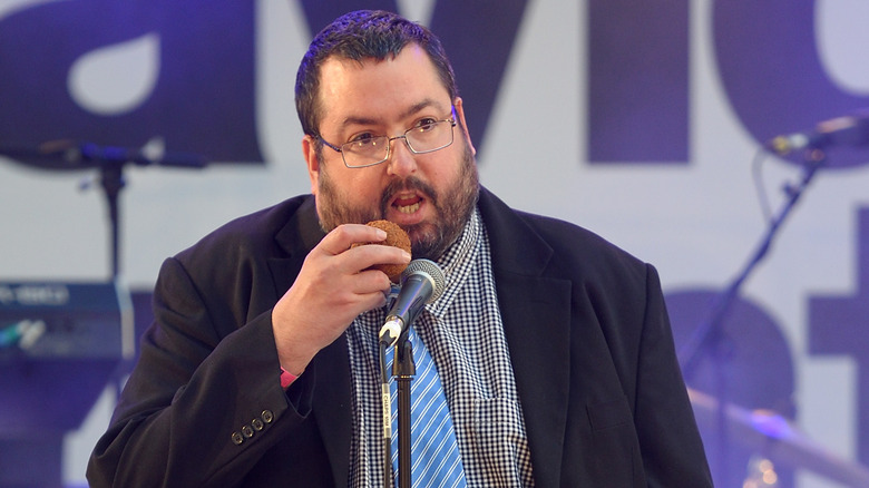 Ewen MacIntosh eating a scotch egg on stage