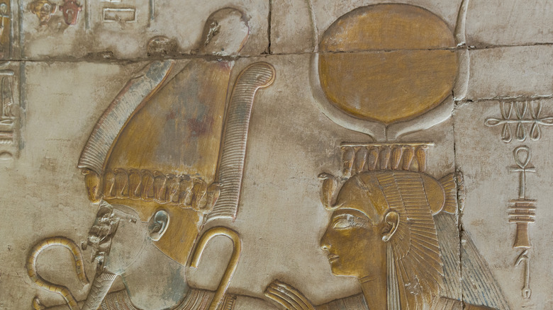 Carving of Isis standing behind Osiris