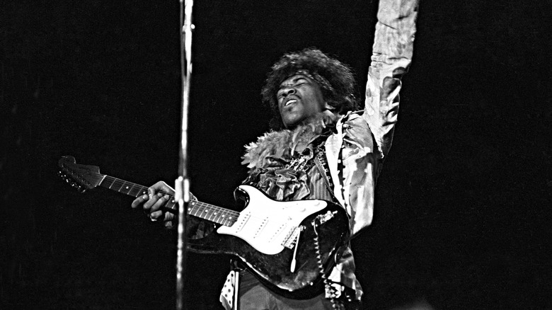 Jimmy Hendrix performing with arm in the air