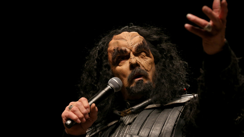 actor J G Hertzler speaks onstage in full klingon makeup, 2019