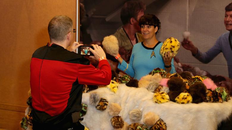 fans pose with prop tribbles at a 2018 star trek convention
