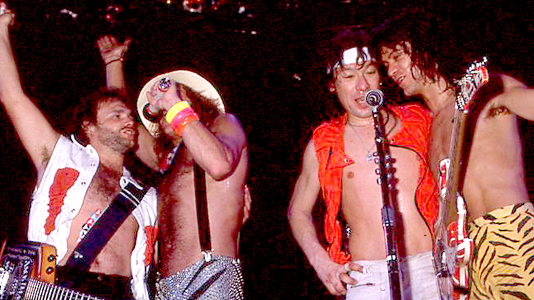Van Halen boisterously performing onstage in the 1980s