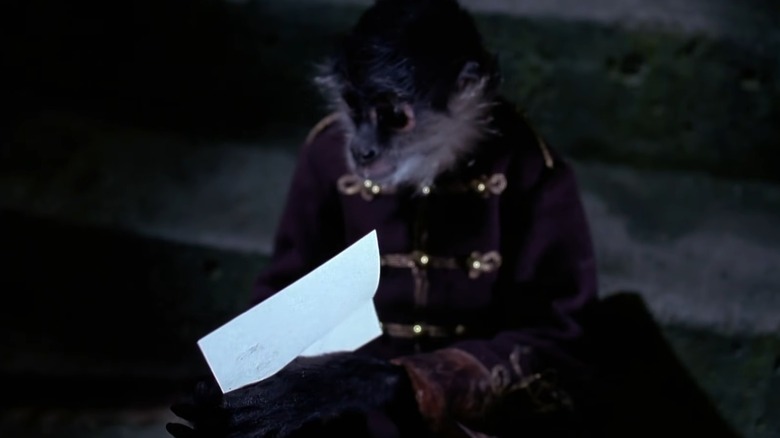A monkey wearing a suit and holding a note