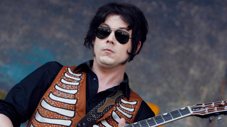 Jack White playing guitar in sunglasses