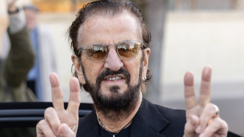 Ringo Starr flashing peace signs