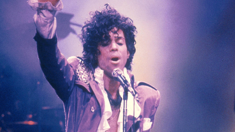 Prince singing on stage in Purple Rain era