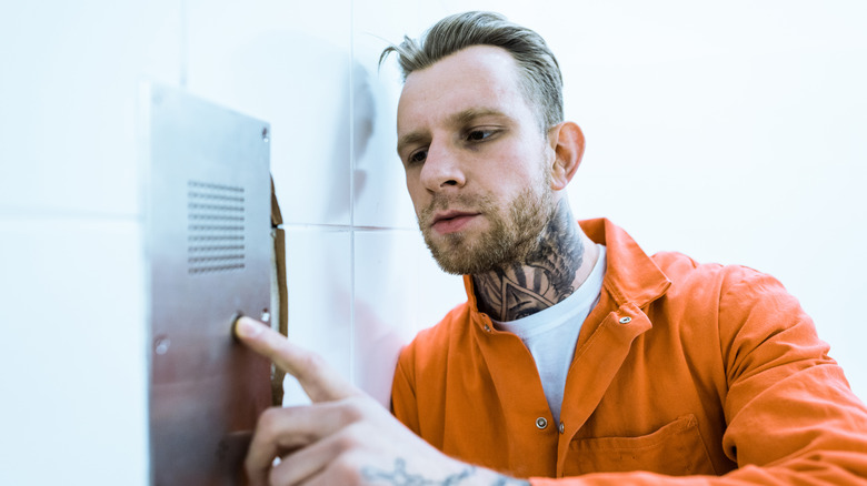 prisoner pressing button in cell