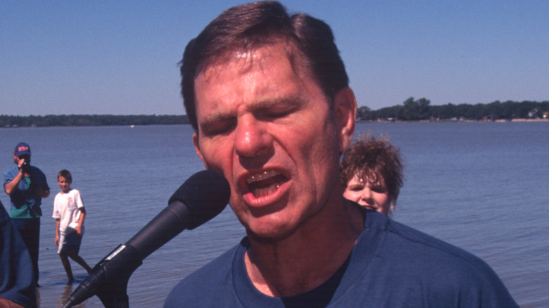 Kenneth Copeland eyes closed talking into microphone