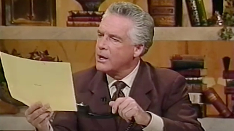 robert tilton reading paper and holding phone receiver