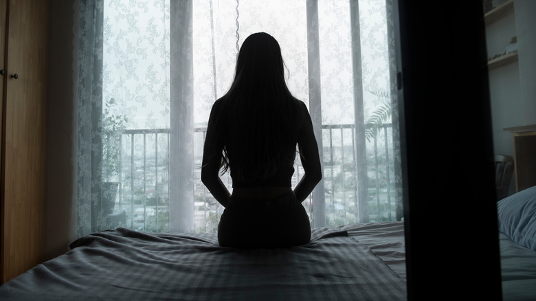 silhouette of woman sitting on bed