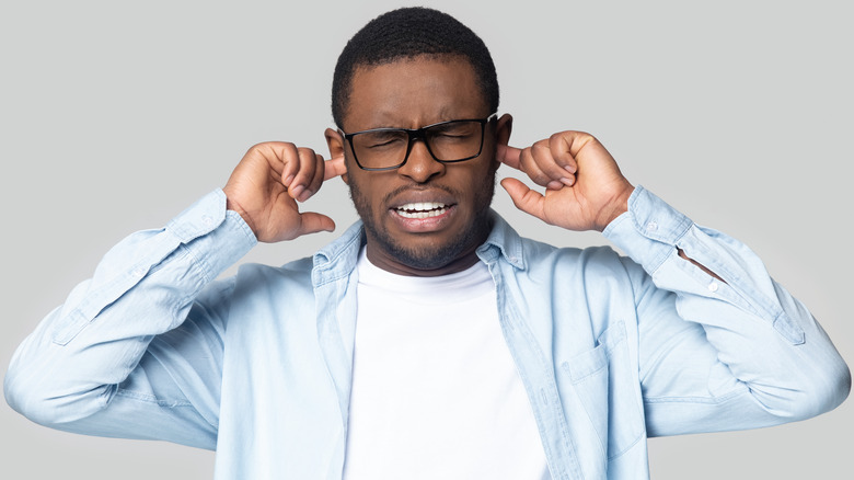 man with ears plugged