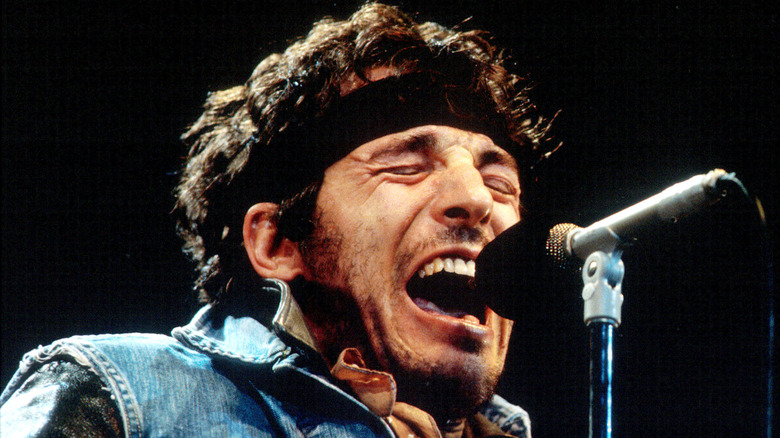 Bruce Springsteen singing on stage with eyes closed in 1985