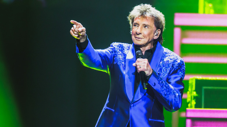 Barry Manilow on stage pointing into the audience