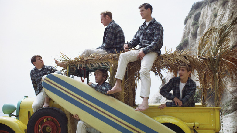 The Beach Boys sitting on an old truck on the beach