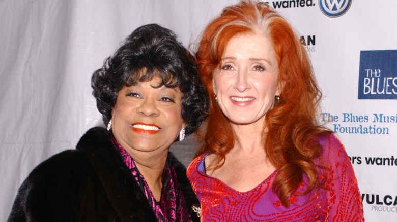 Ruth Brown and Bonnie Raitt smiling and posing together at an event