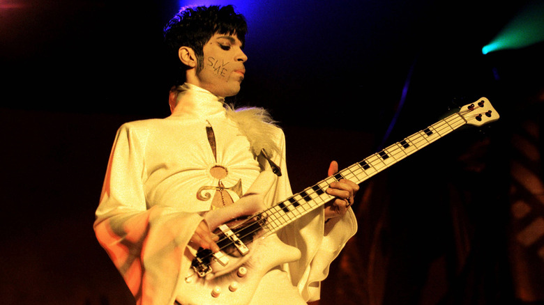 Prince playing bass guitar on stage