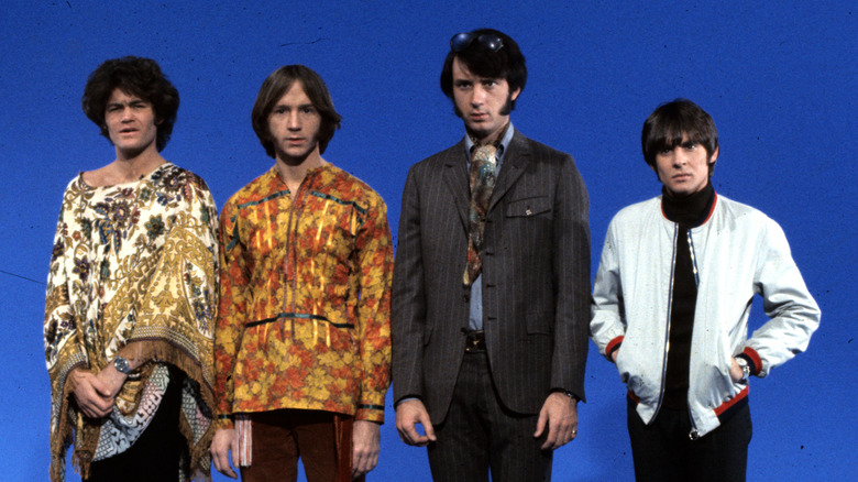 The Monkees photographed in front of a blue background