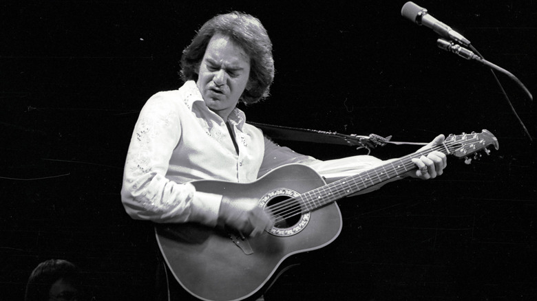 Neil Diamond playing guitar onstage