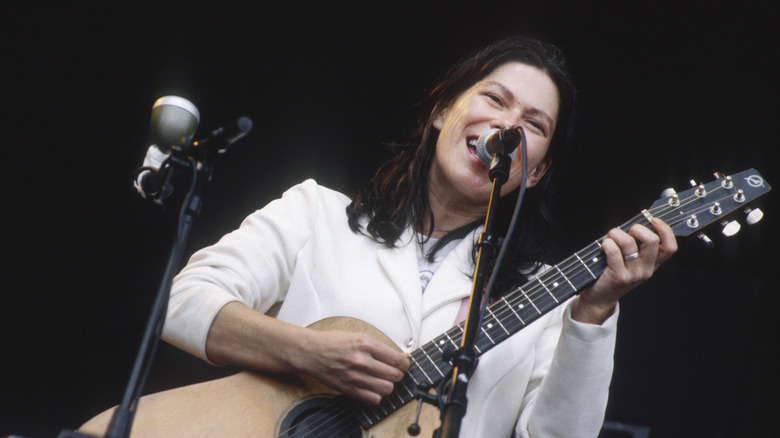 Kim Deal of The Breeders on stage with guitar and microphone