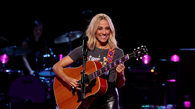 Sheryl Crow singing and playing guitar