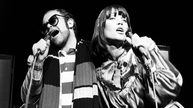Elton John and Kiki Dee singing into handheld mics