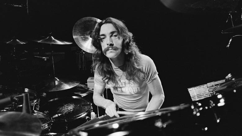 Neil Peart staring into camera from behind drum set