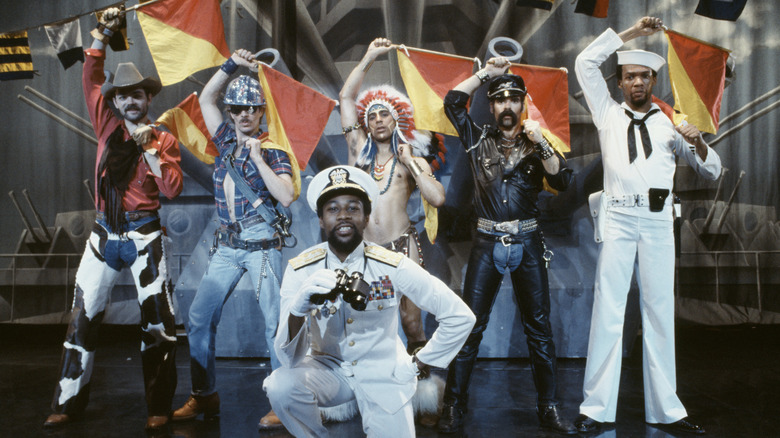 Village People members holding semaphore flags
