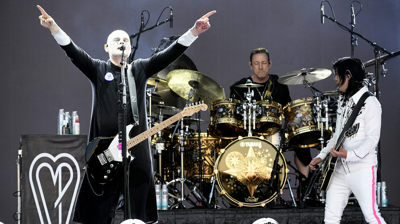 Smashing Pumpkins performing on stage with Billy Corgan gesturing and singing into the microphone.