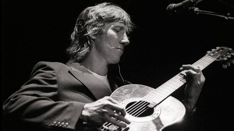 Roger Waters playing acoustic guitar