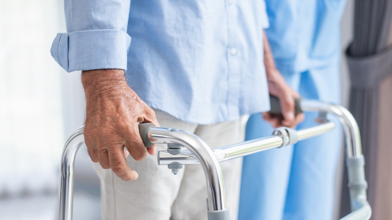 Person with walker being helped by a carer