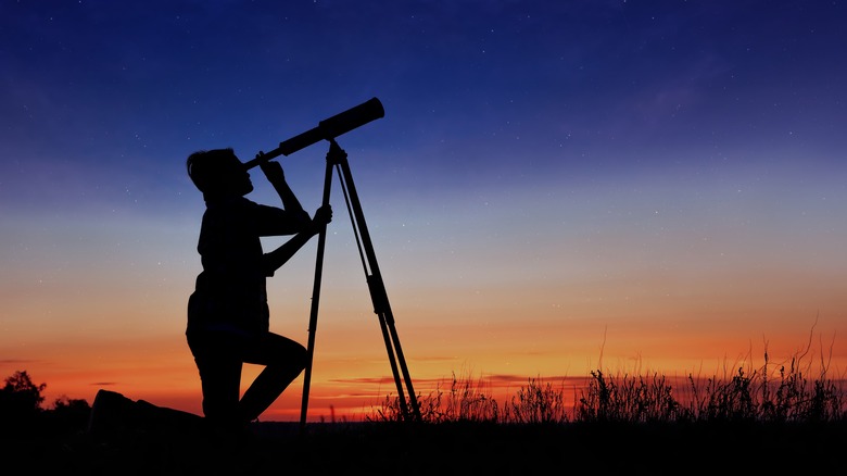 child looking through telescope