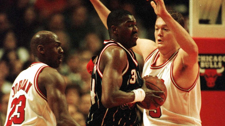 Hakeem Olajuwon guarded by Michael Jordan and Luc Longley