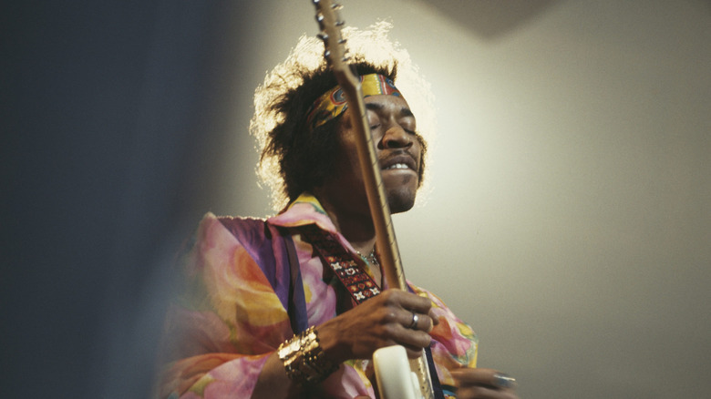 Jimi Hendrix playing guitar on stage