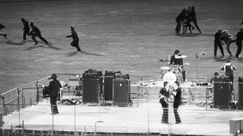 The Beatles play Candlestick Park while guards chase fans