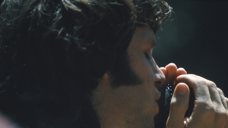 Jim Morrison holding microphone closely