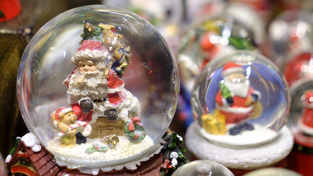 Two snowglobes featuring Santa Claus figurines