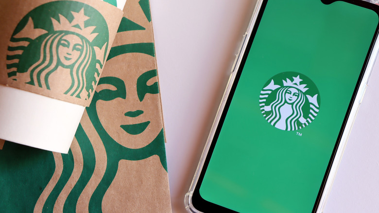 Starbucks cup, bag, and logo on phone