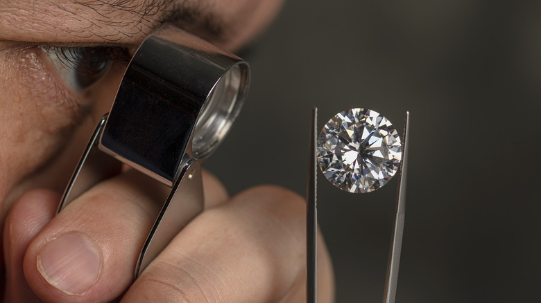 a jeweler inspects a diamond
