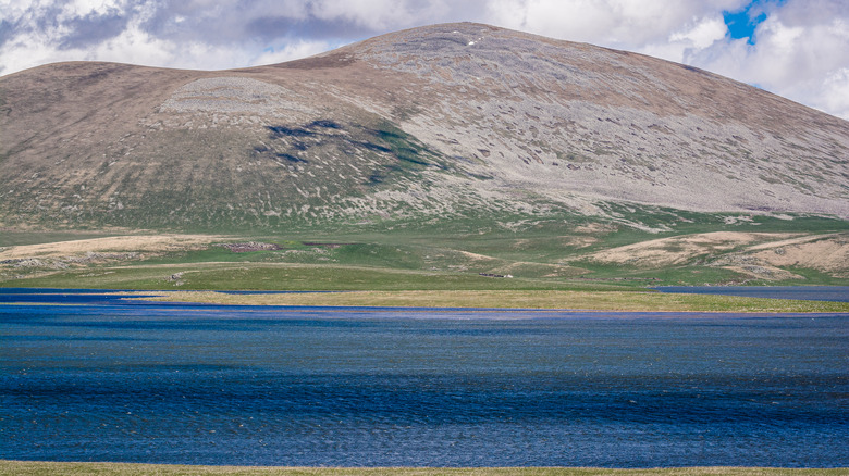 Paravani Lake with hill and blue cloudy sky