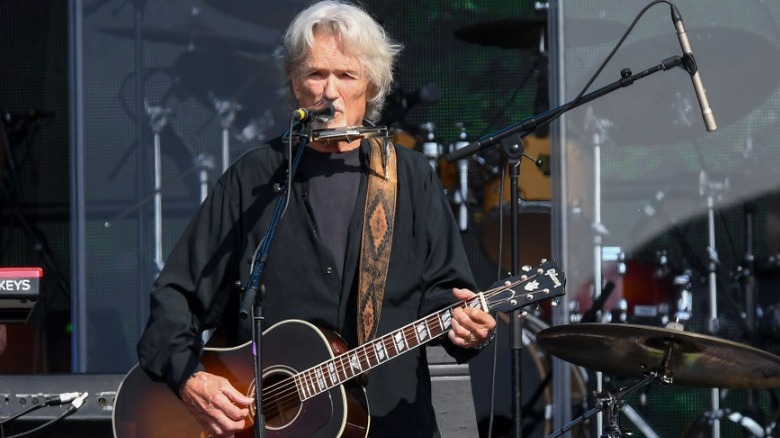 Kris Kristofferson playing guitar onstage
