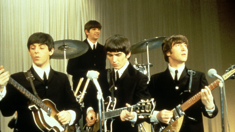 The Beatles playing instruments on a sound stage