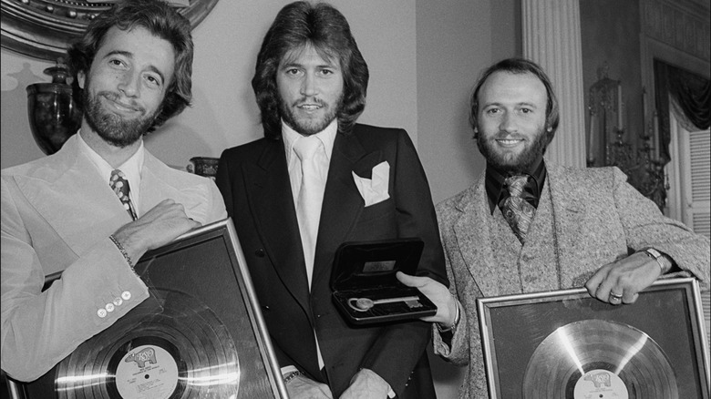 The Bee Gees holding gold records