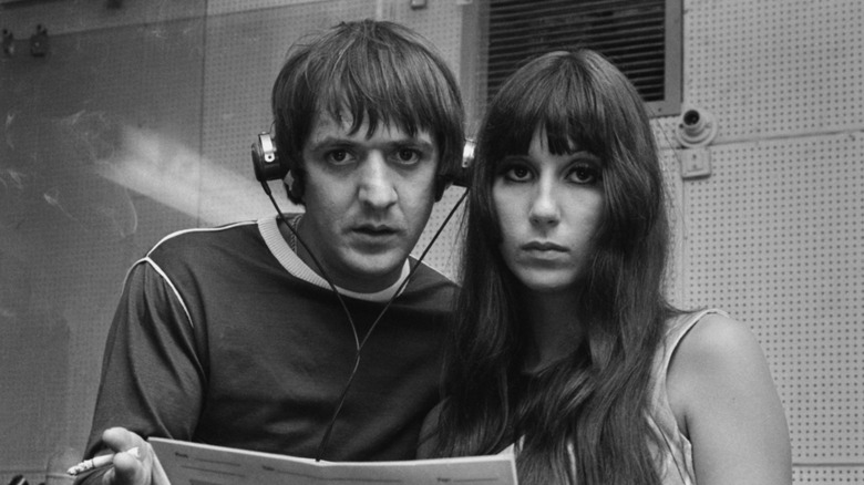 Sonny Bono and Cher holding music in a recording studio