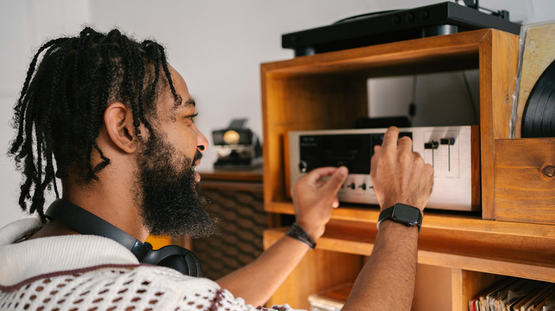 A man adjusting a hi-fi setup