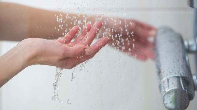 Lady checking shower temperature